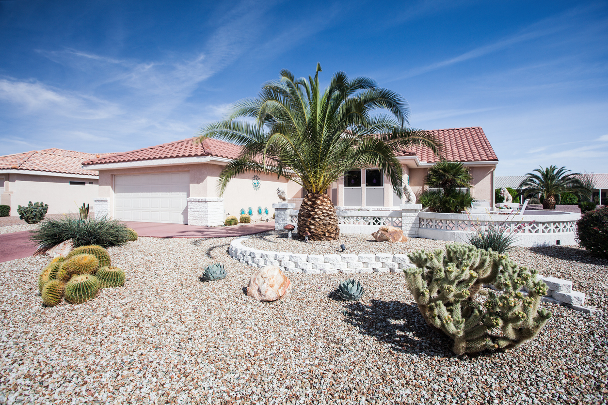 A southwestern home exterior featuring a rock garden with succulents and native plants.