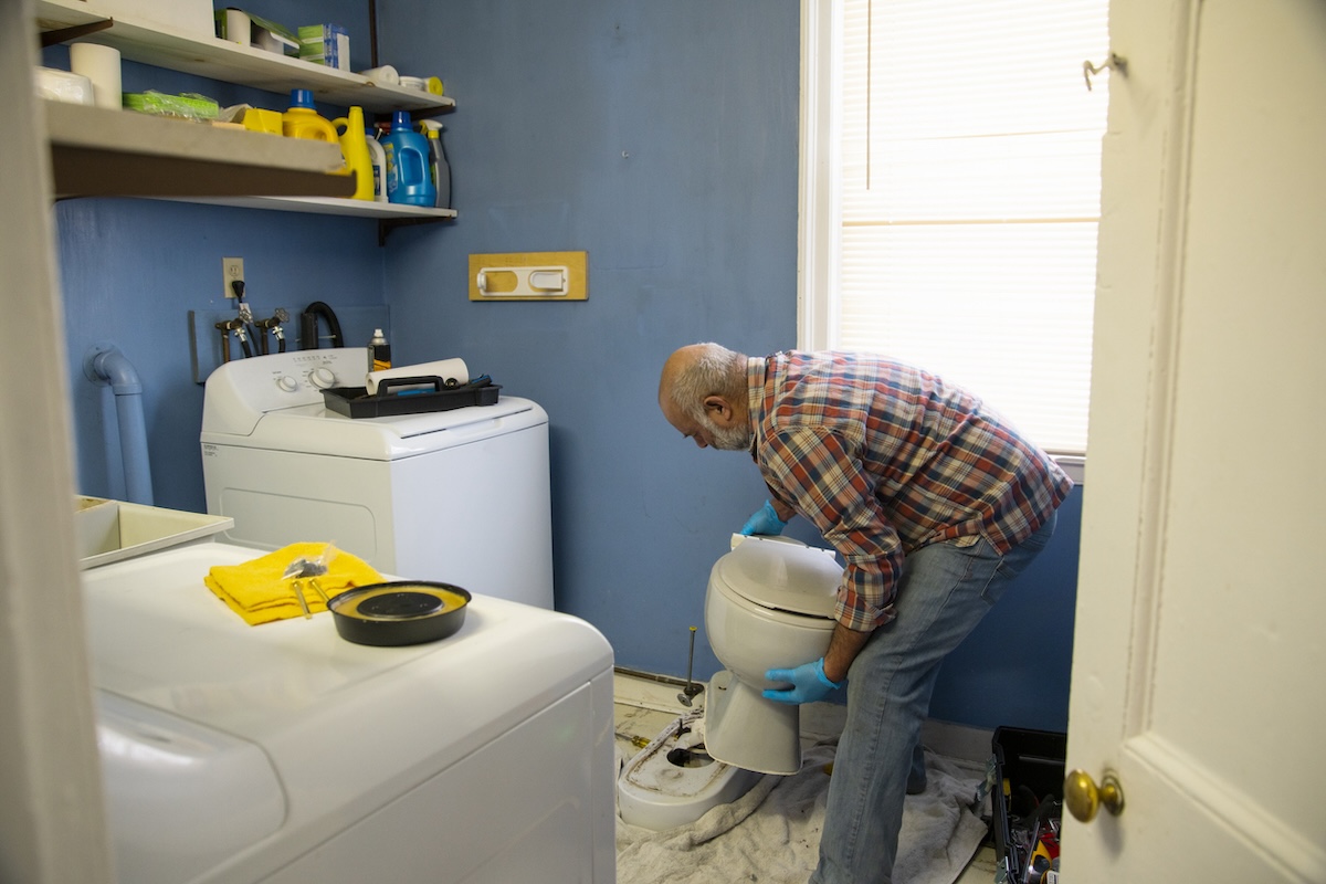 Plumber fixes toilet.