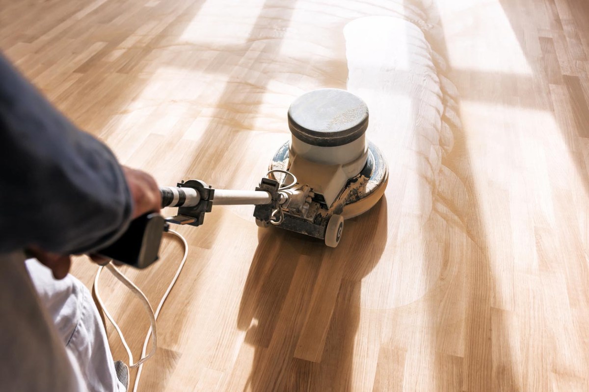 A close up of a floor sander in action.