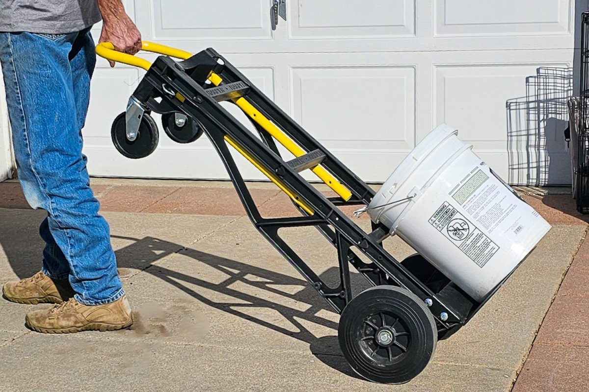 A person using the Harper Convertible Hand Truck to move a heavy 5-gallon bucket.