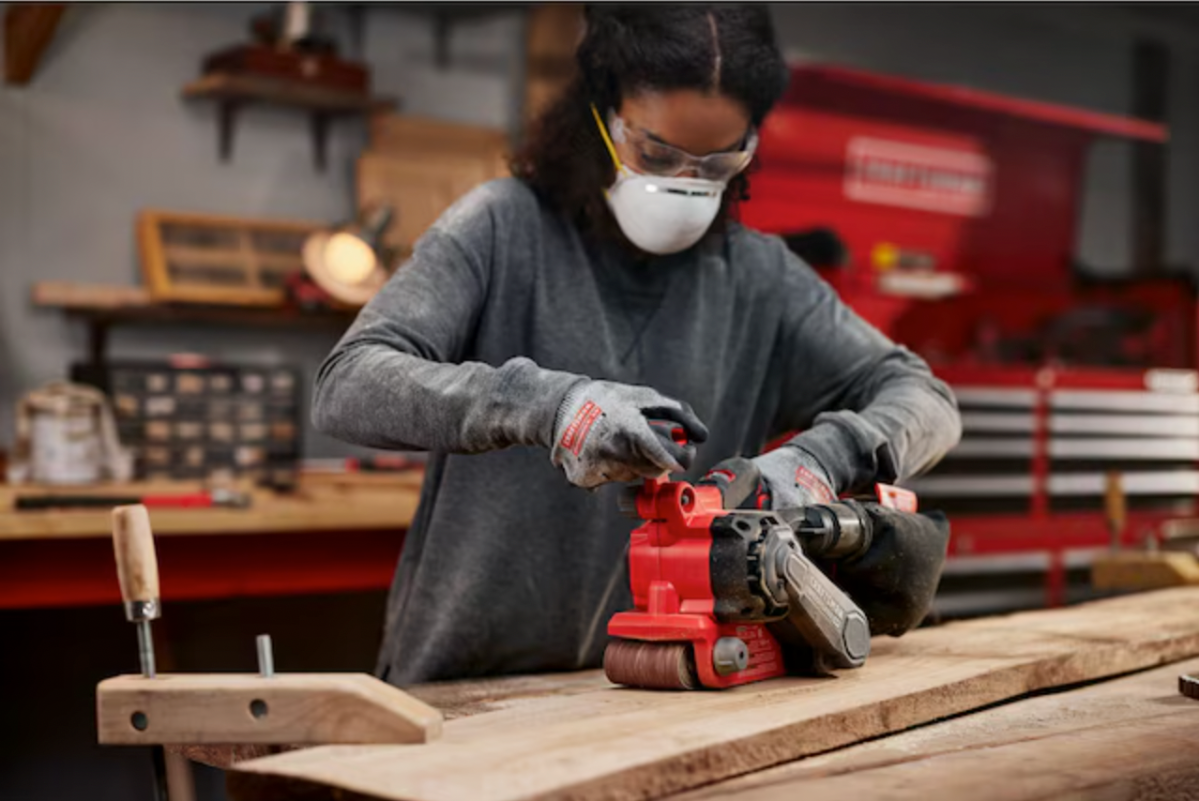 Women using Craftsman sander on piece of wood 