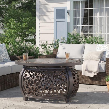  The Fleur De Lis Living Slattery Propane Fire Pit Table set up with drinks on top.