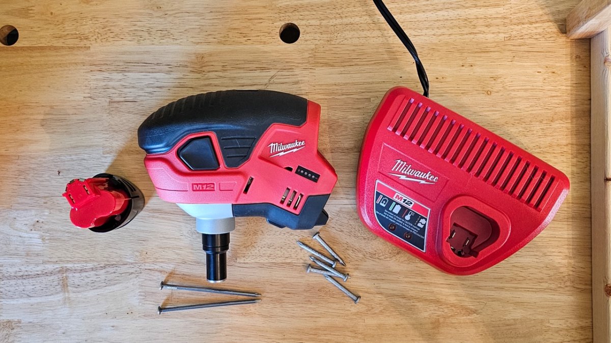 The best palm nailer and some nails on a piece of wood during testing.