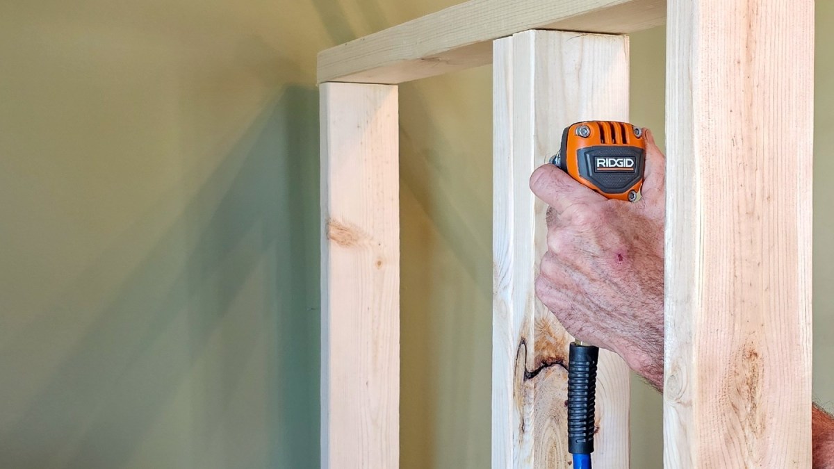 A person using the Ridgid Mini Palm Nailer to install framing during testing.