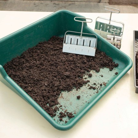  The Johnny’s Soil Blocking and Potting Tray filled with soil on a table.
