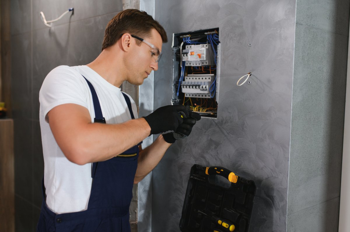 A view of a worker fixing an electrical component.