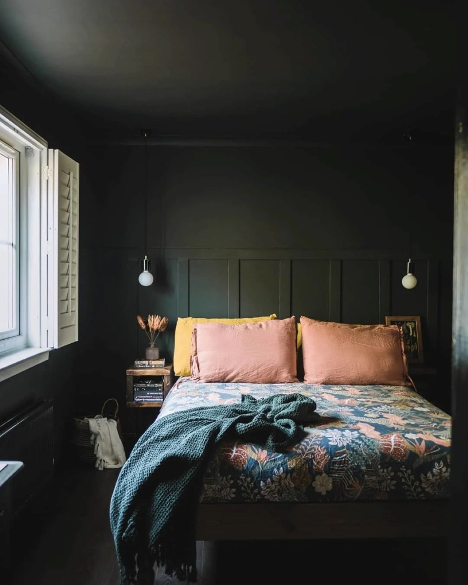 A bedroom with dark green walls and ceiling.