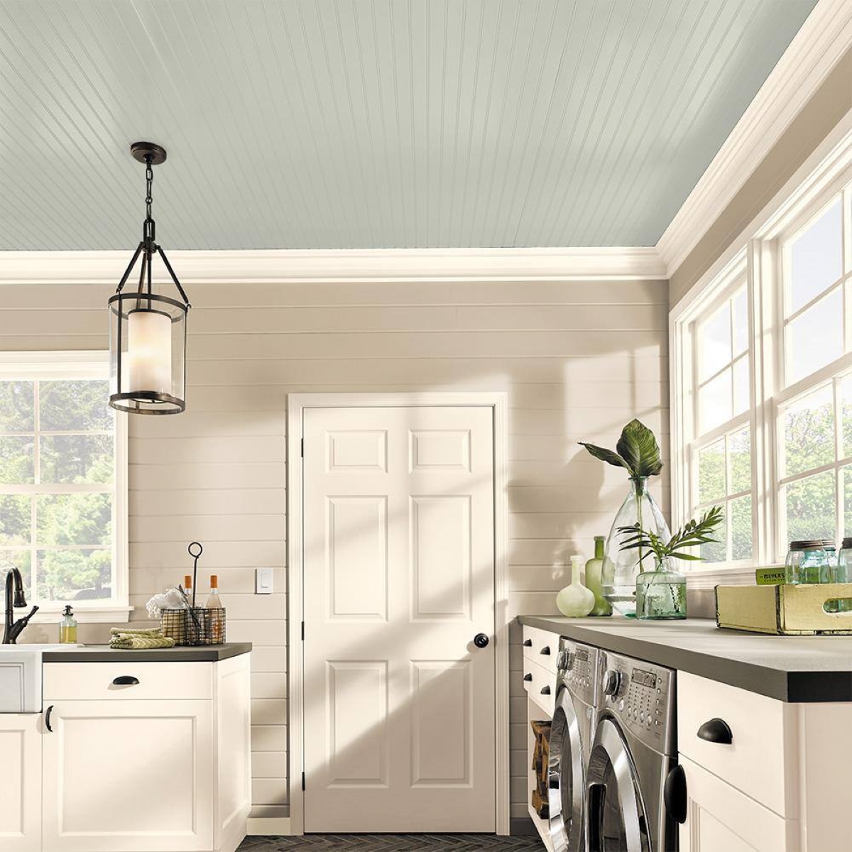 A kitchen and laundry room with a light sage colored ceiling.
