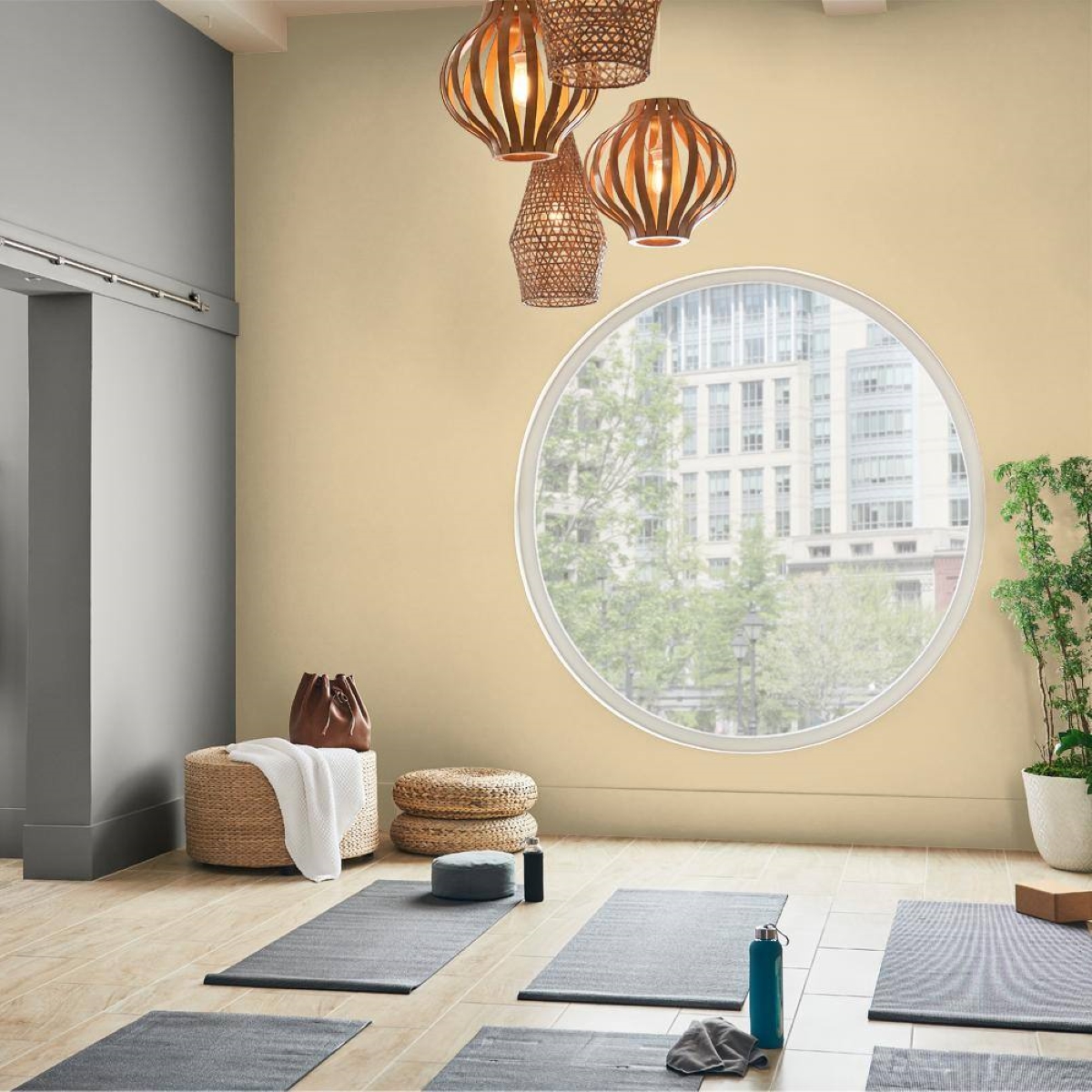 A light yellow painted yoga room with a large circular window.