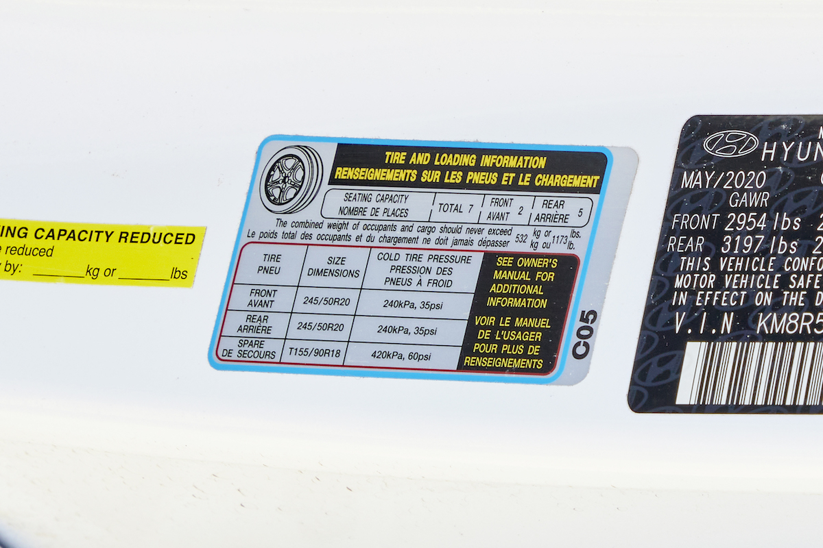 Manufacturer recommendations for tire pressure on the inside of a car door.