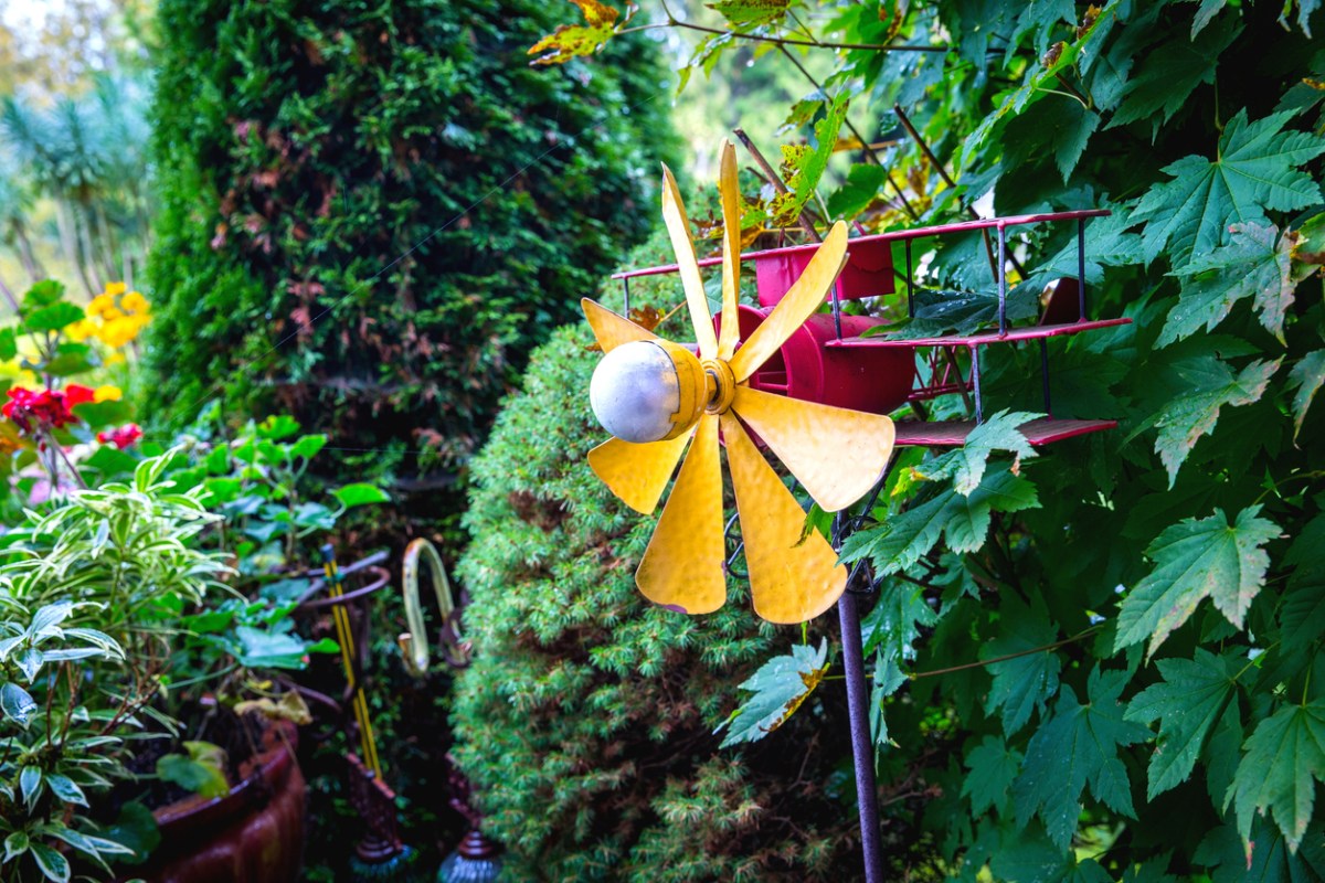 A-plane-whirligig-pinwheel-is-in-a-lush-garden.