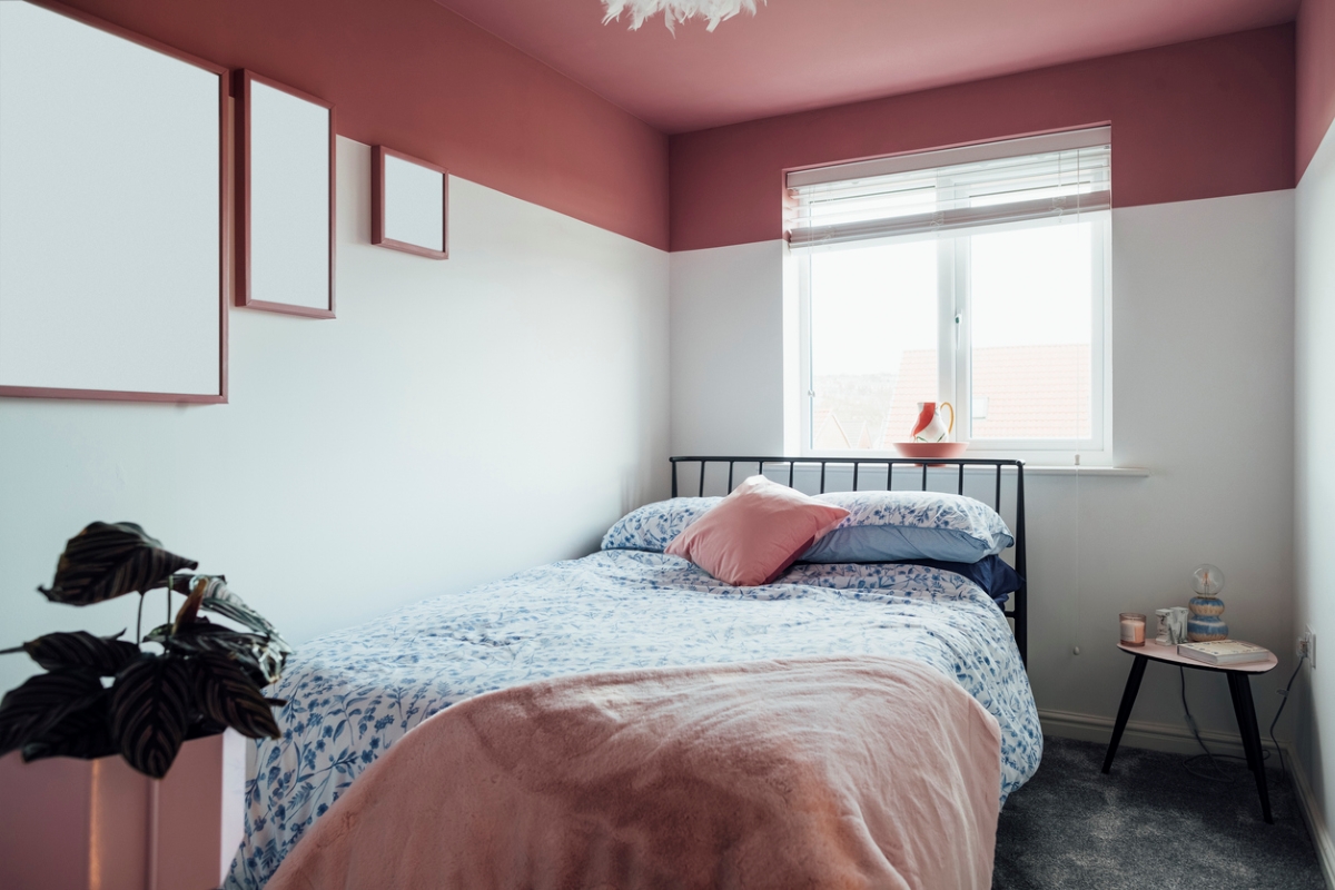 A modern bedroom with dark pink ceiling.