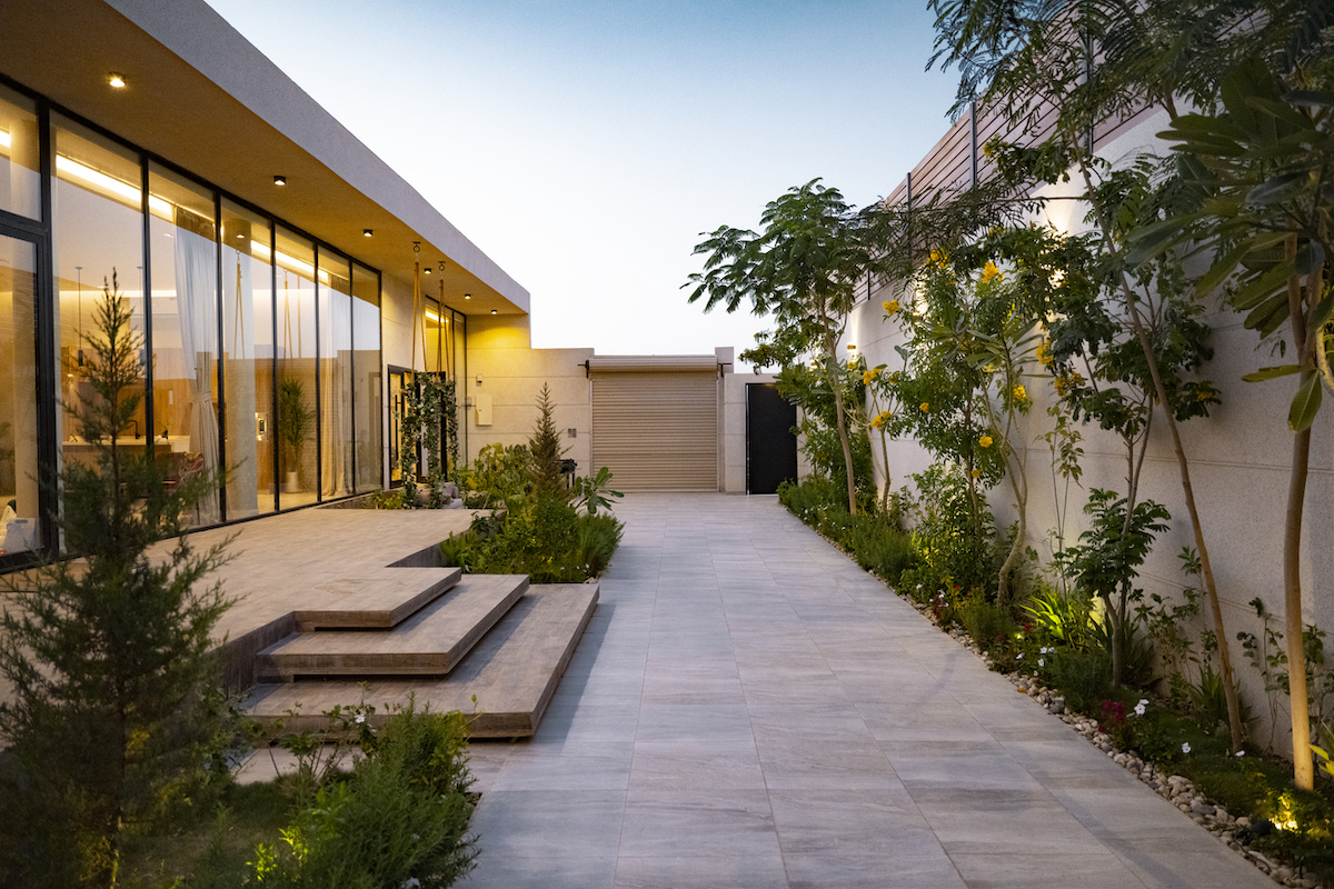 Native plant landscaping enhances a modern home and patio's stone and glass features.