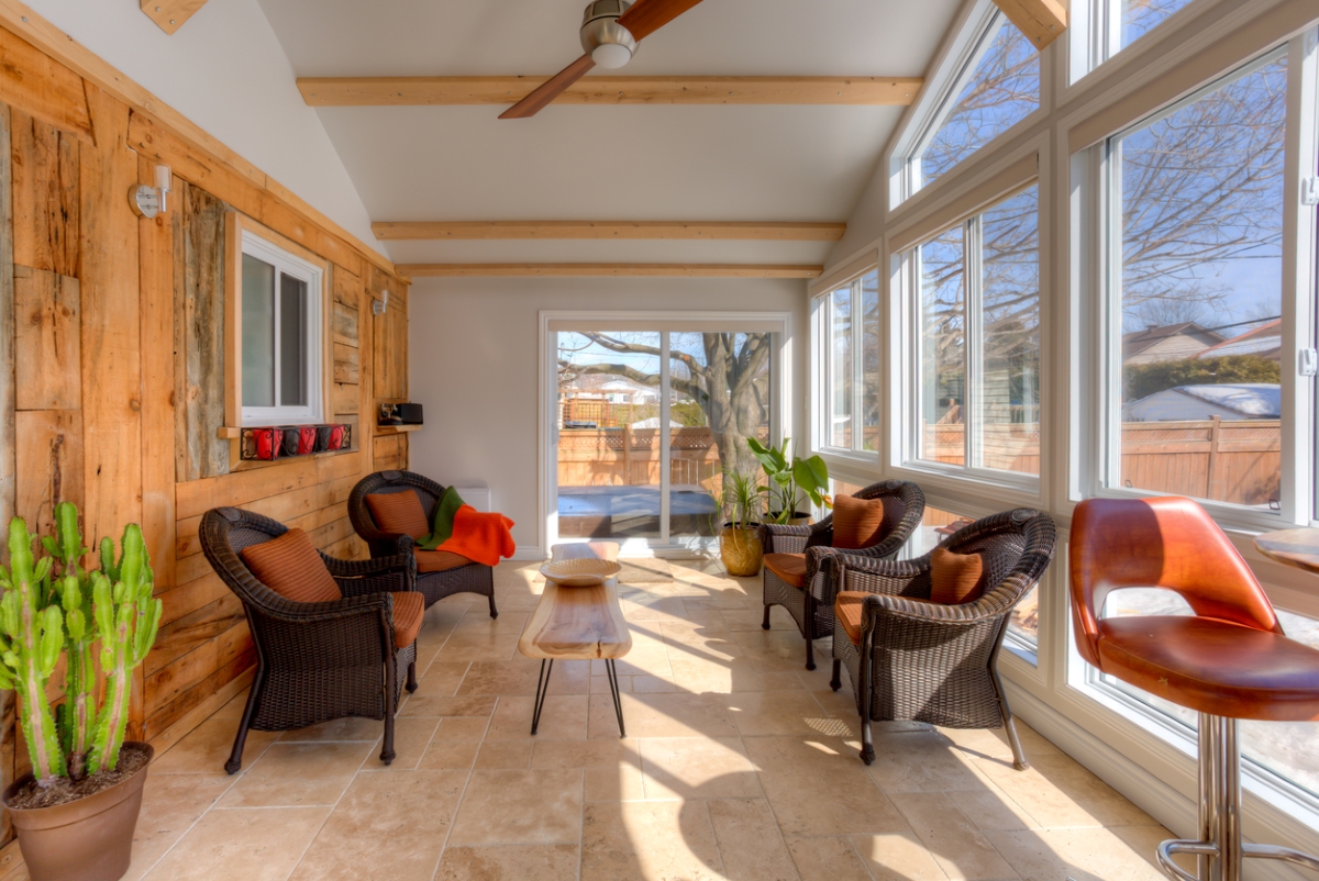 A large sunroom addition with furniture and windows.