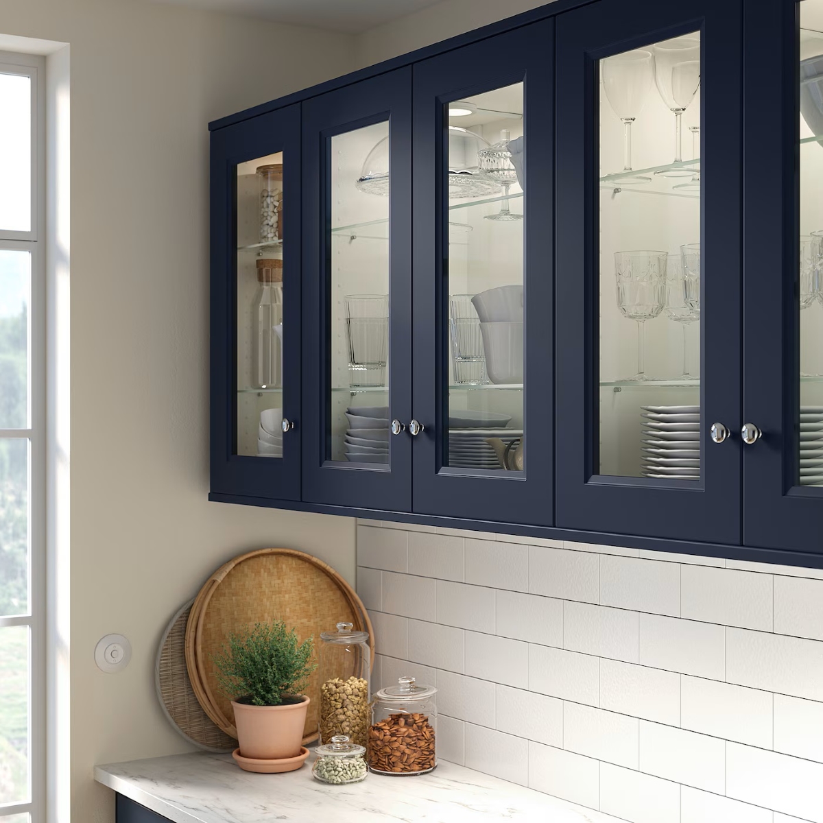 Dark blue kitchen cabinets with glass doors.