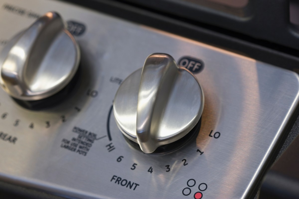 Close up of two stainless steel knobs on a stove.