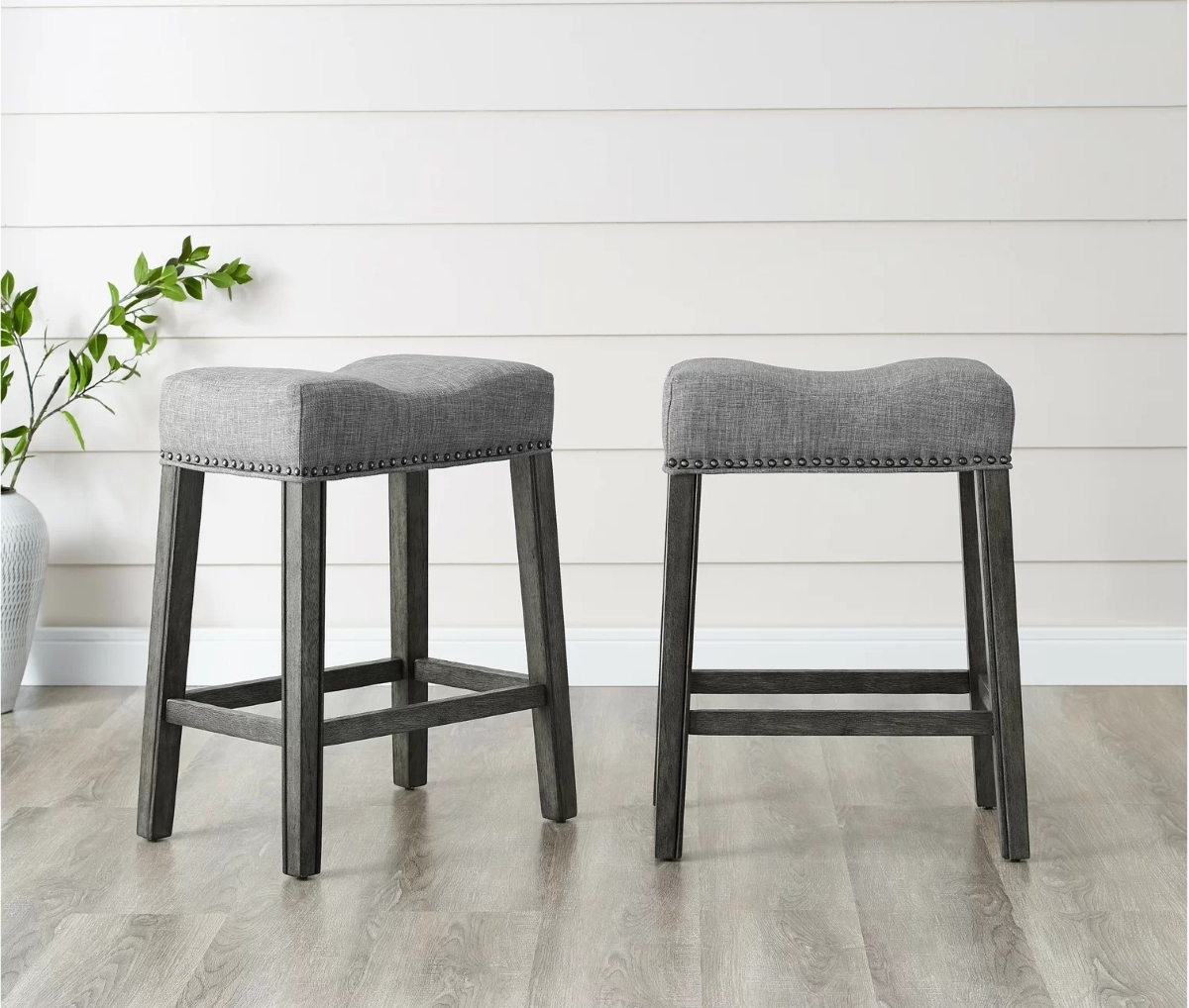 Two counter seats with gray fabric seats and wooden frames.