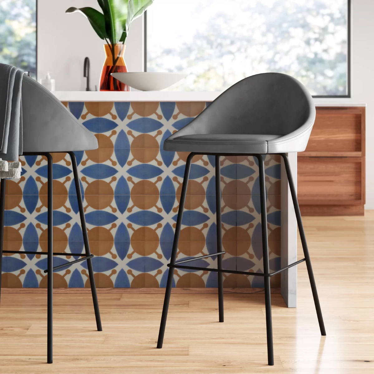 Gray bar counter stools with black metal frame in a colorful kitchen.