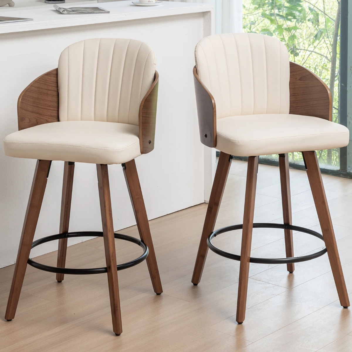 Two white swivel counter stools with wooden frames.