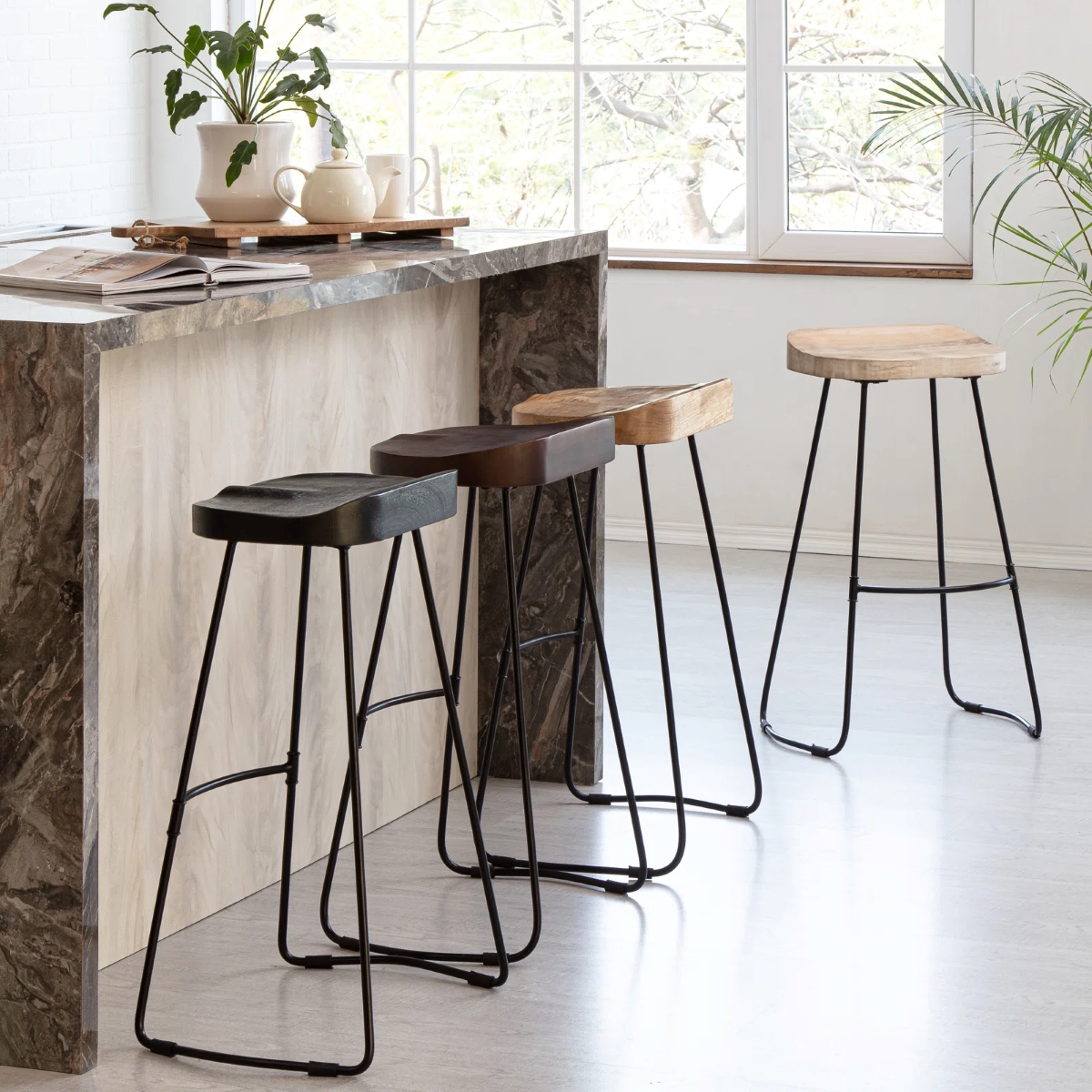 Modern wooden kitchen island seats with thin metal frames.
