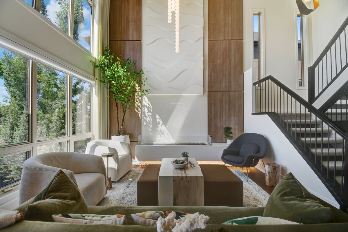 A warm neutral living room with full length windows shows soft furnishings and organic materials.