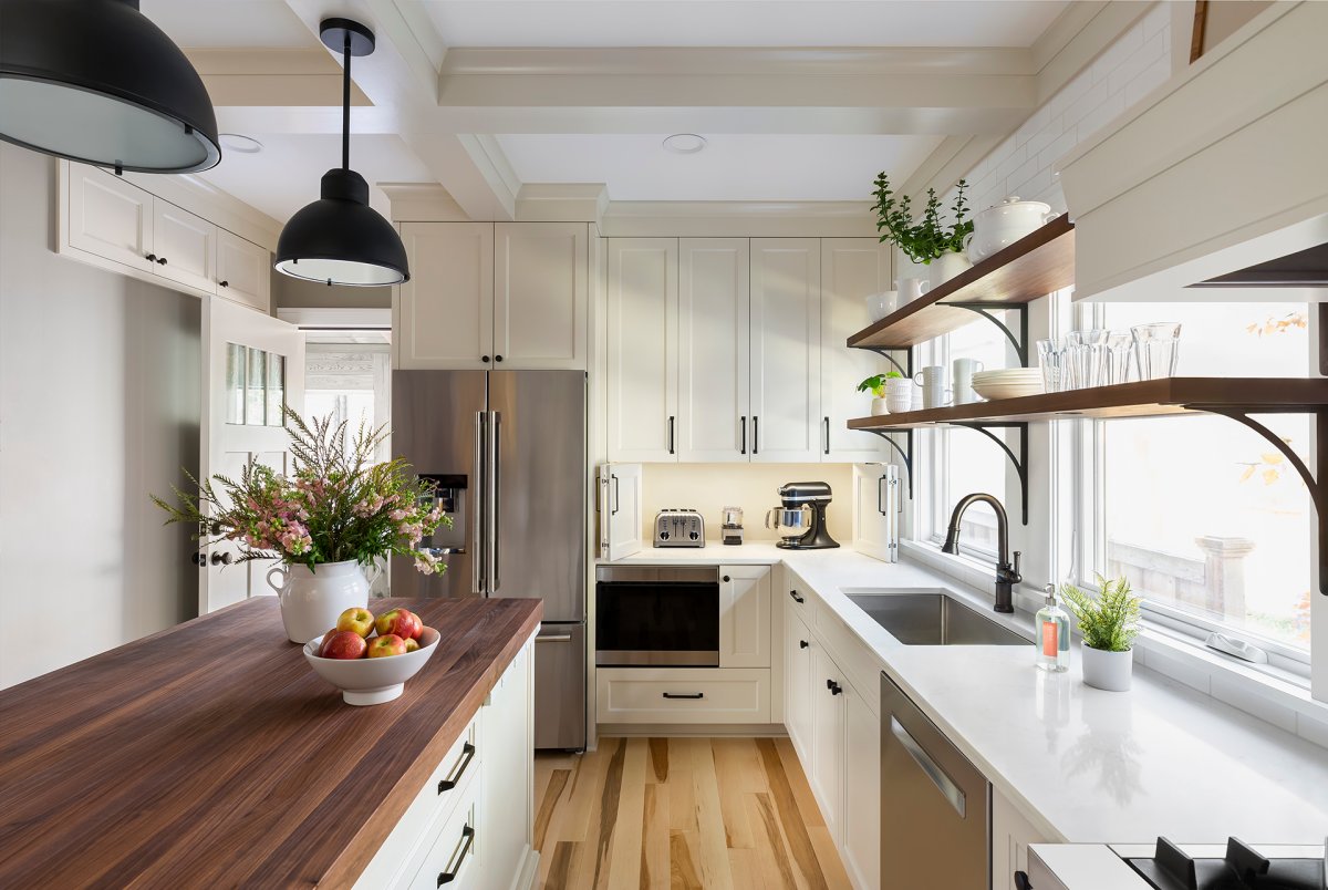 Kitchen with cream colored cabinets and walnut countertop and shelves with appliance garage open.