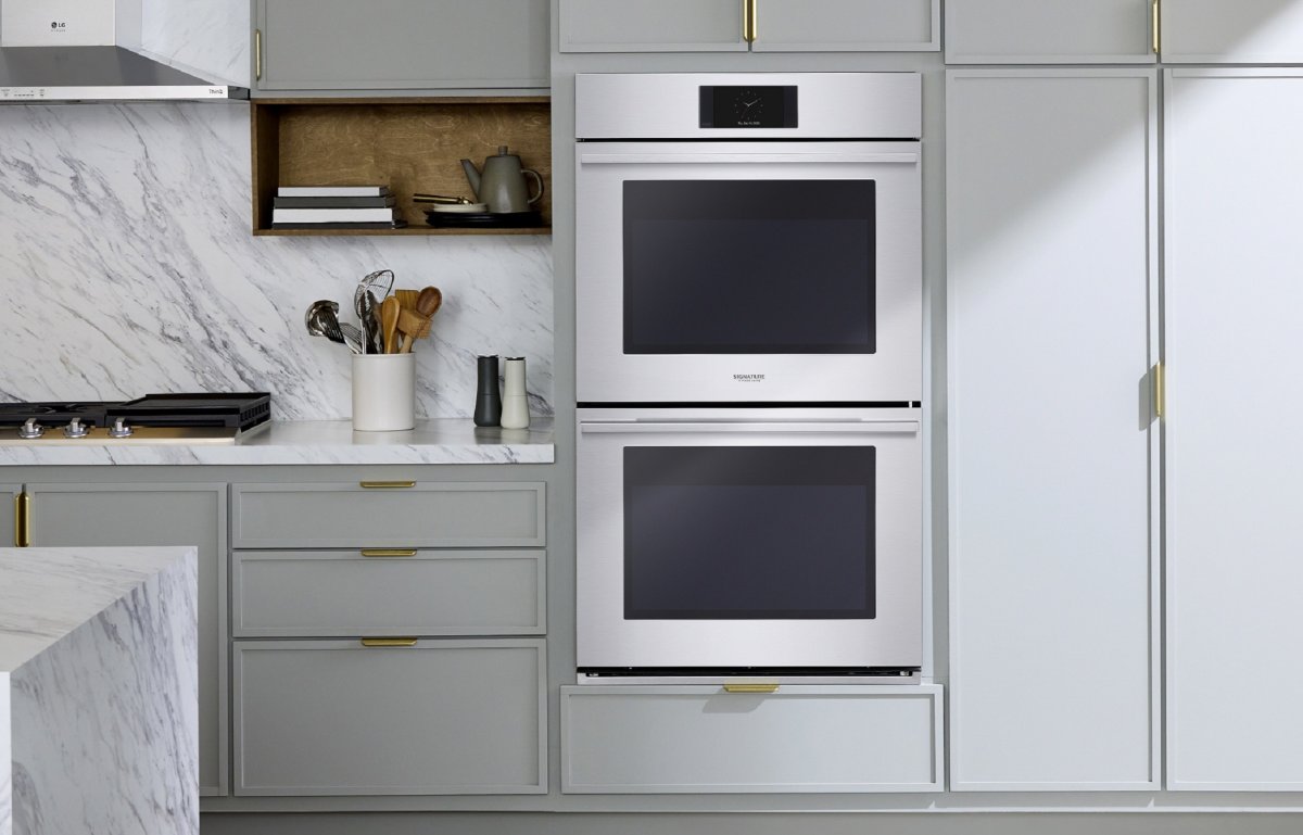 A sage and marble kitchen features two built-in ranges by LG.