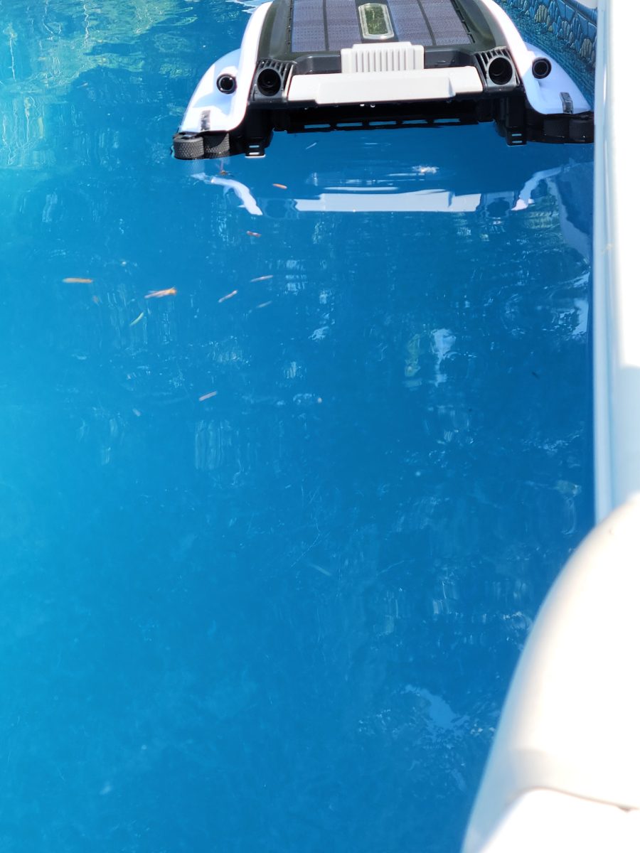 Betta robotic pool skimmer in pool with debris in front of it