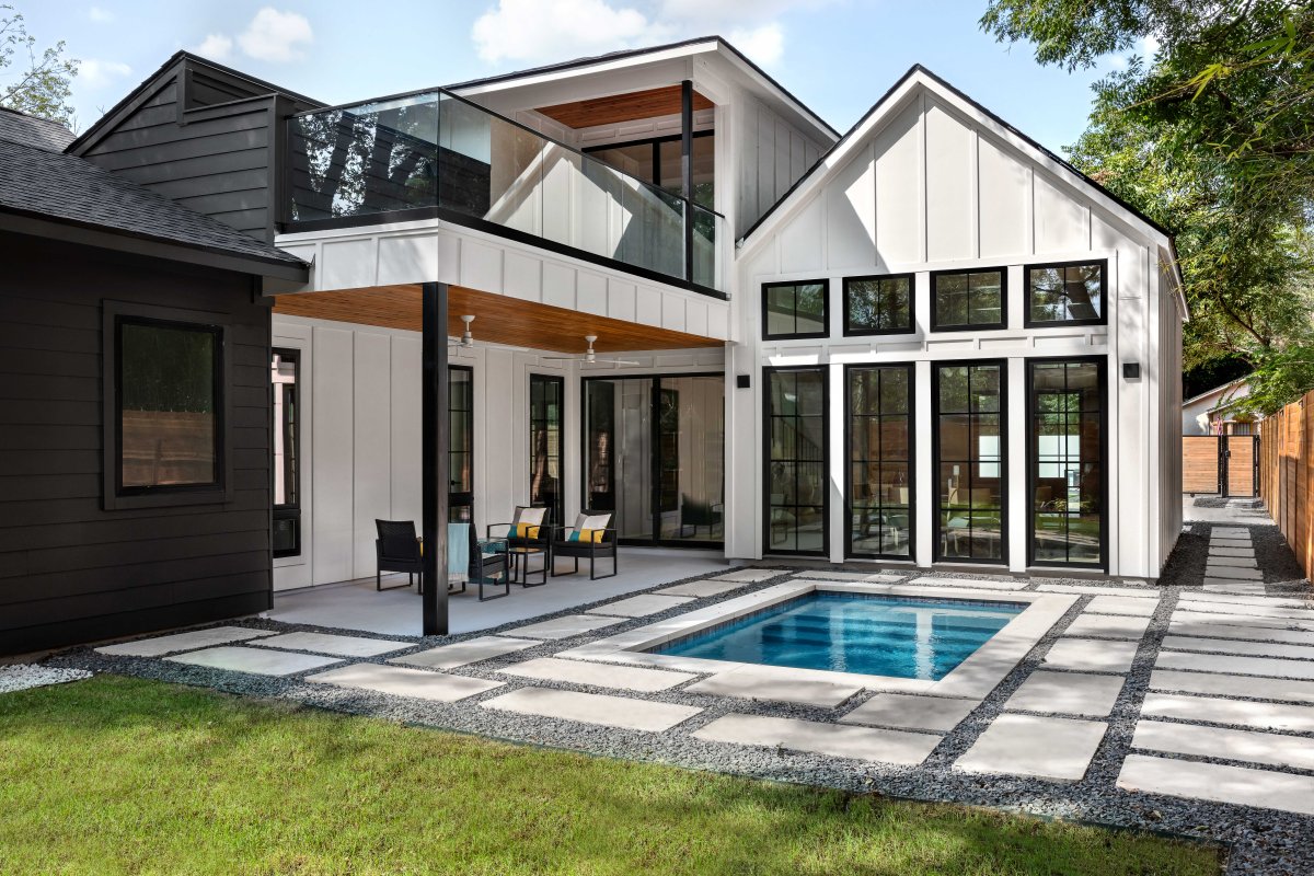 A plunge pool is surrounded by flagstones in the backyard of a contemporary home.