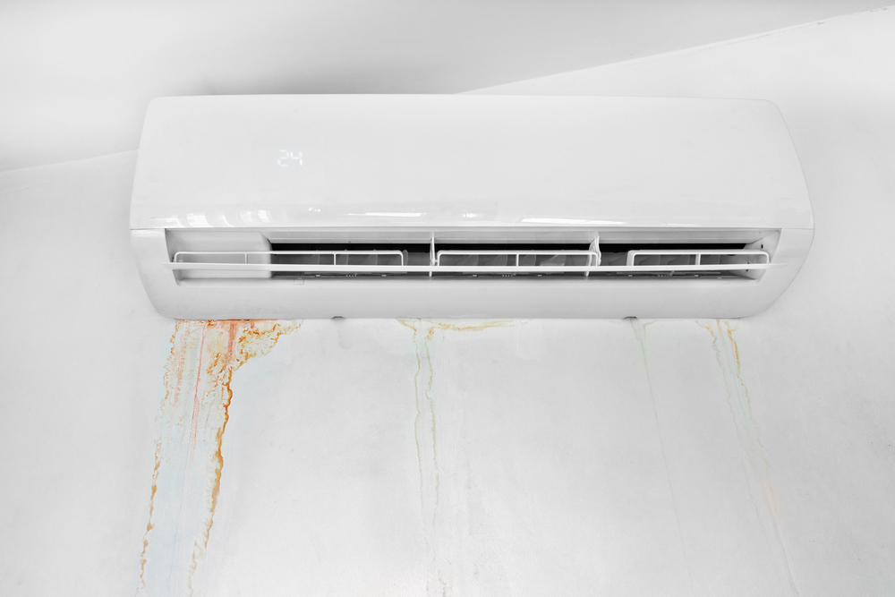 A leaking AC mounted on a white wall. 