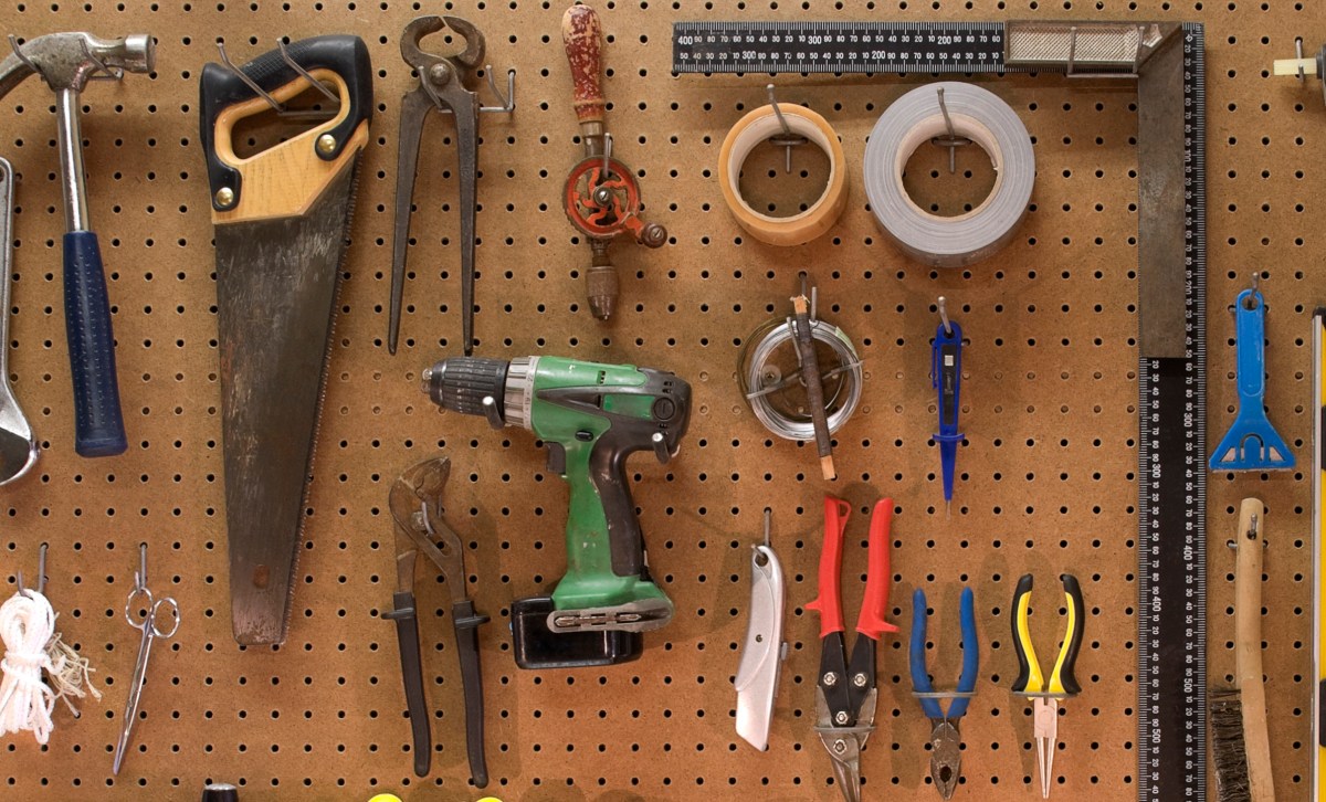 Duct tape hanging on pegboard with a collection of tools for home improvement projects.