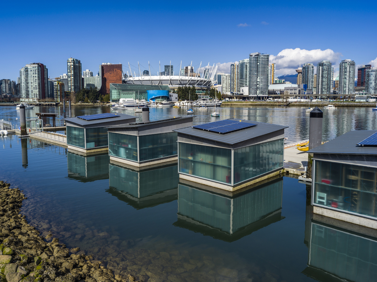 Four floating homes are lined along the Vancouver, Canada skyline.