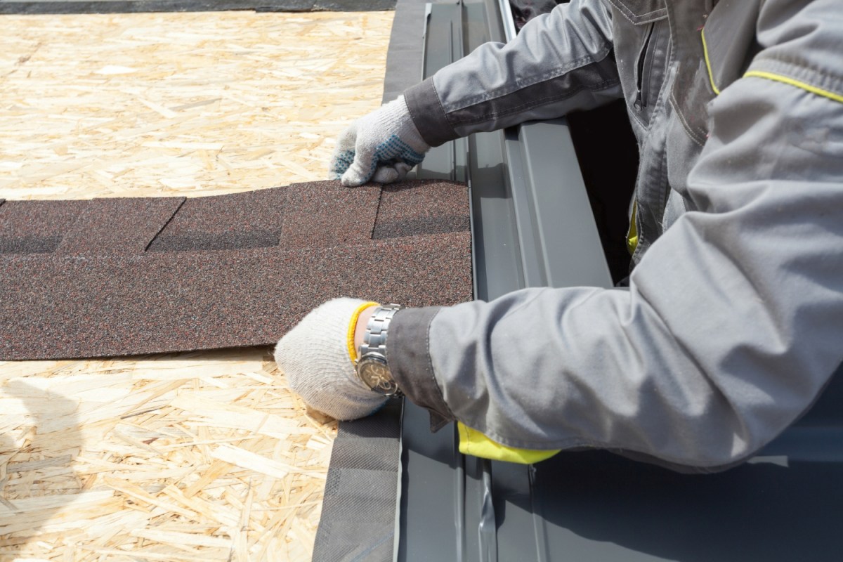 A close up of a roofer repairing a roof.