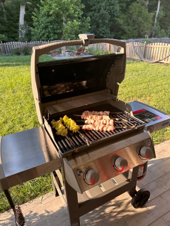 Food sitting on cast iron grates of Weber E-310 grill