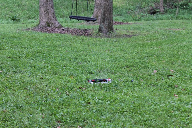 The OtO Lawn Sprinkler watering a green lawn during testing.