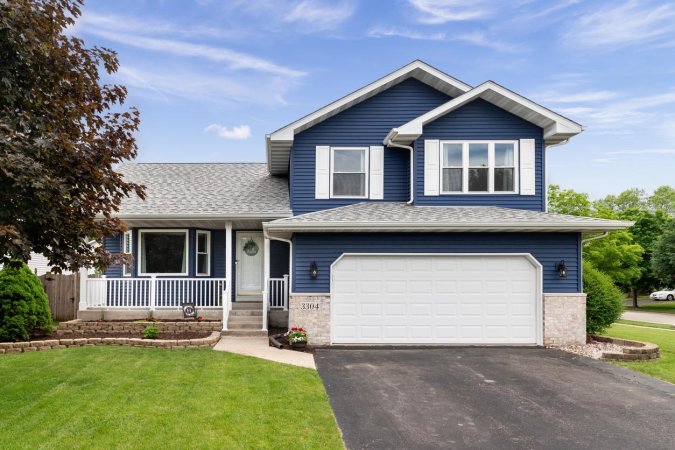 A view of a large blue home on a sunny day.