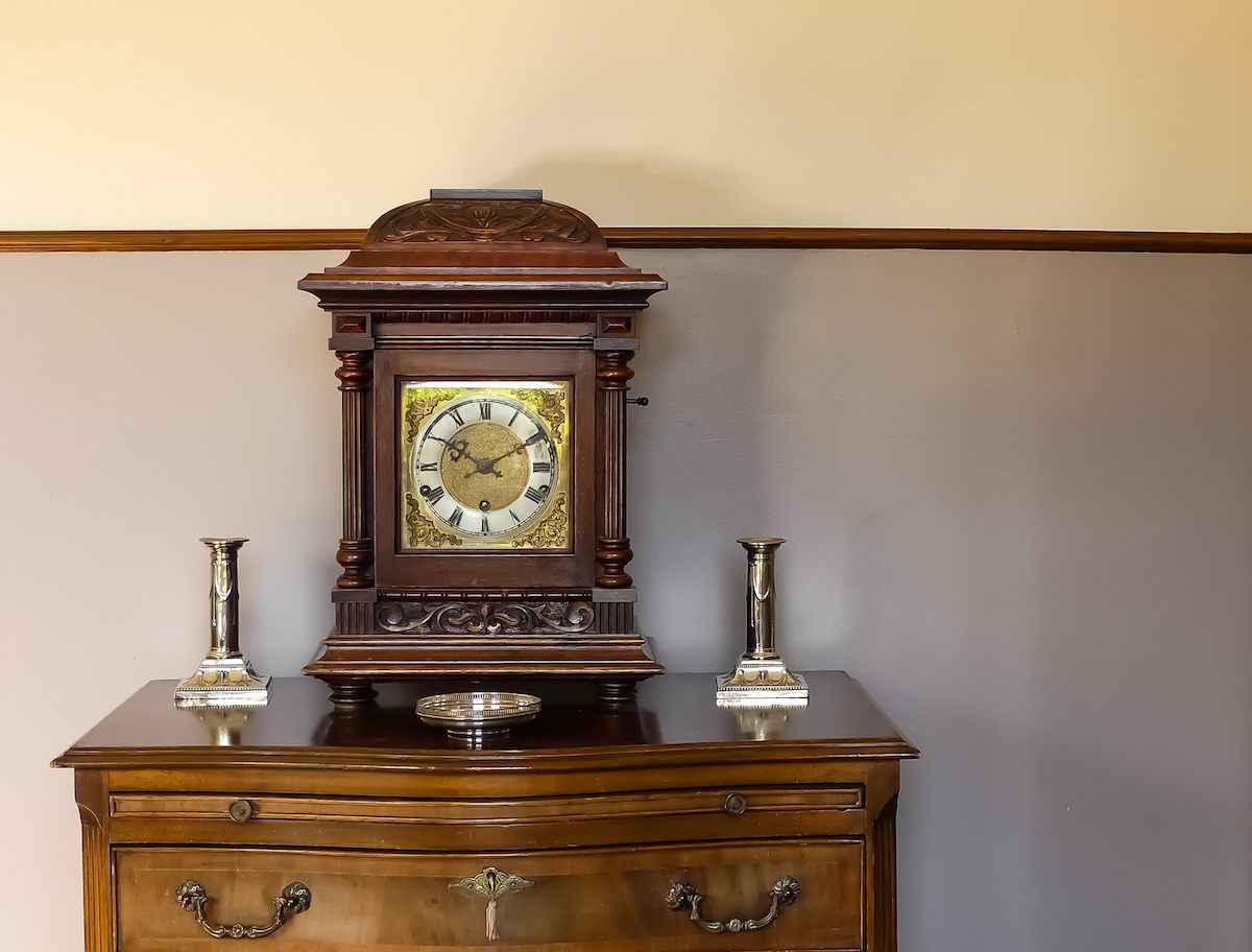 Antique mantel clock with storage at its base.