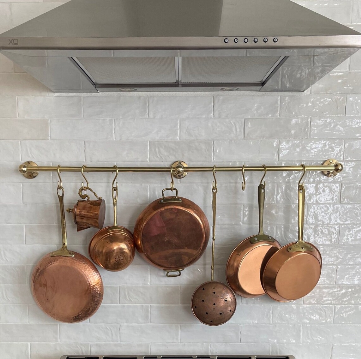 Copper pots hanging from kitchen wall.