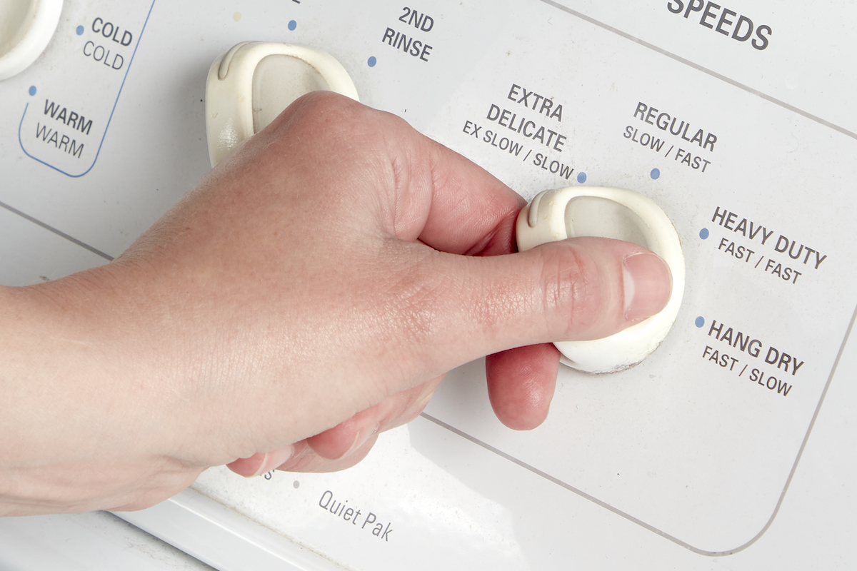 Woman turns the dial on her washing machine to "extra delicate."