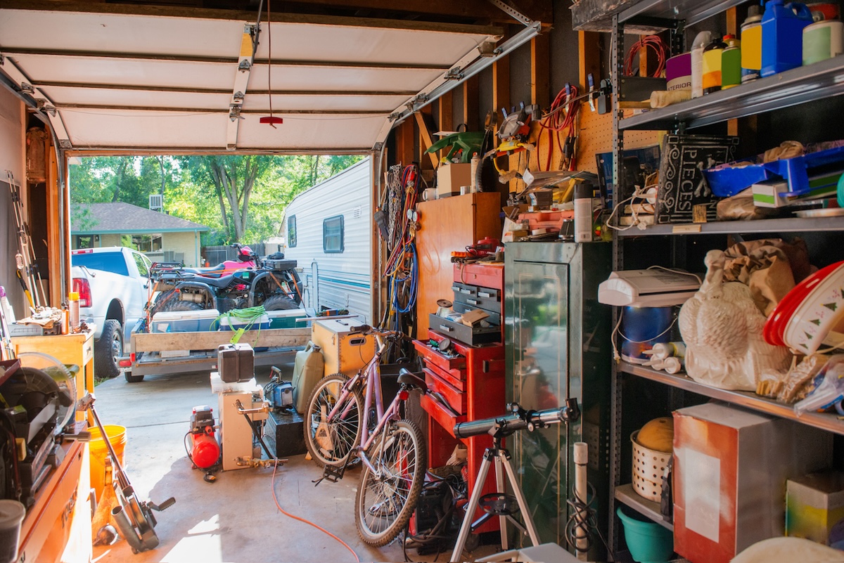 A messy garage in summer waiting to be cleaned.