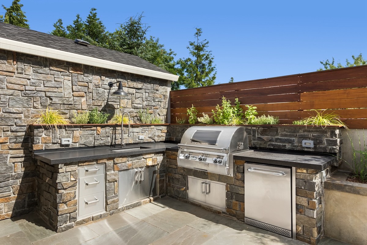 A new outdoor kitchen with a natural gas grill and other outdoor kitchen appliances.