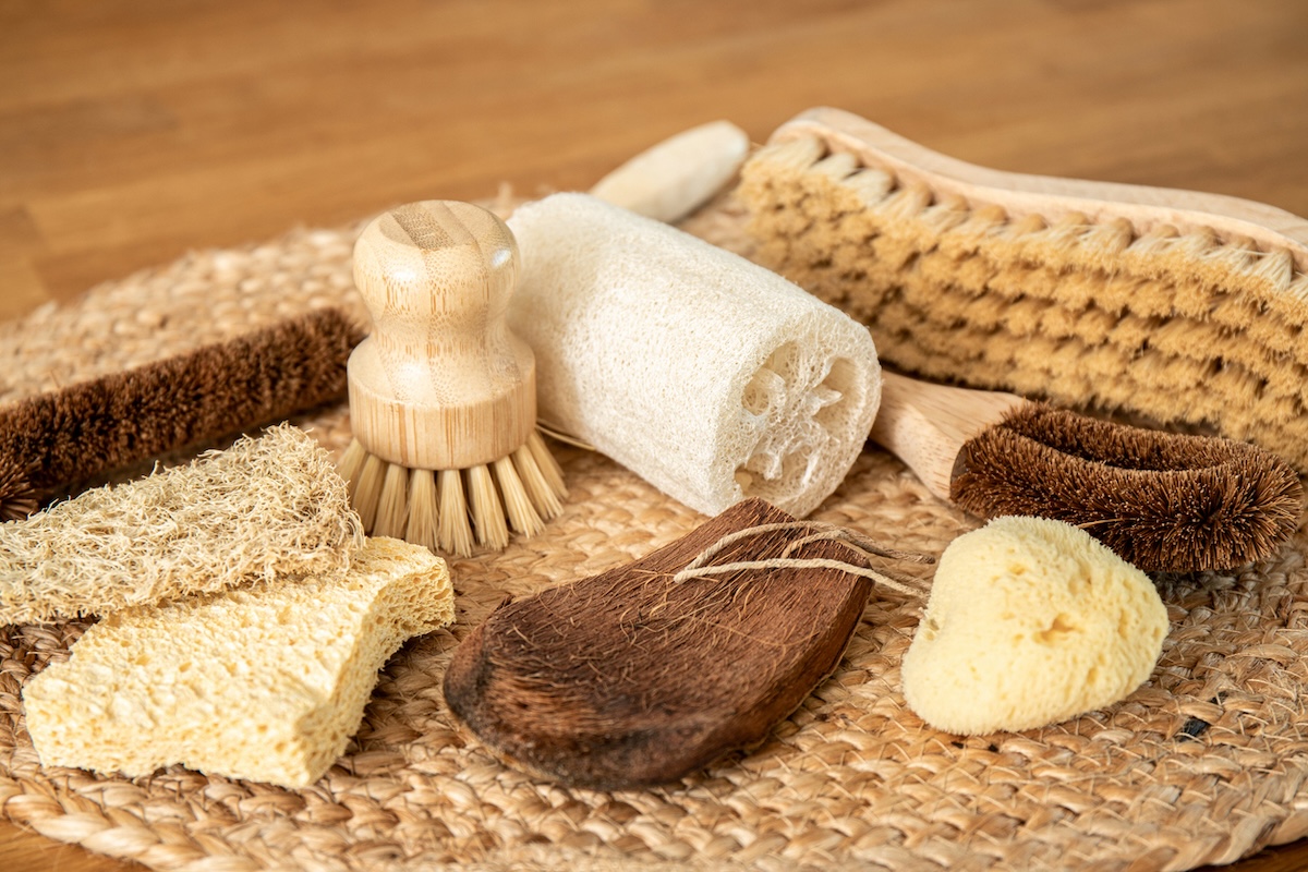 A group of cleaning tools made out of all-natural materials like coconut, bamboo, loofa, wood pulp.