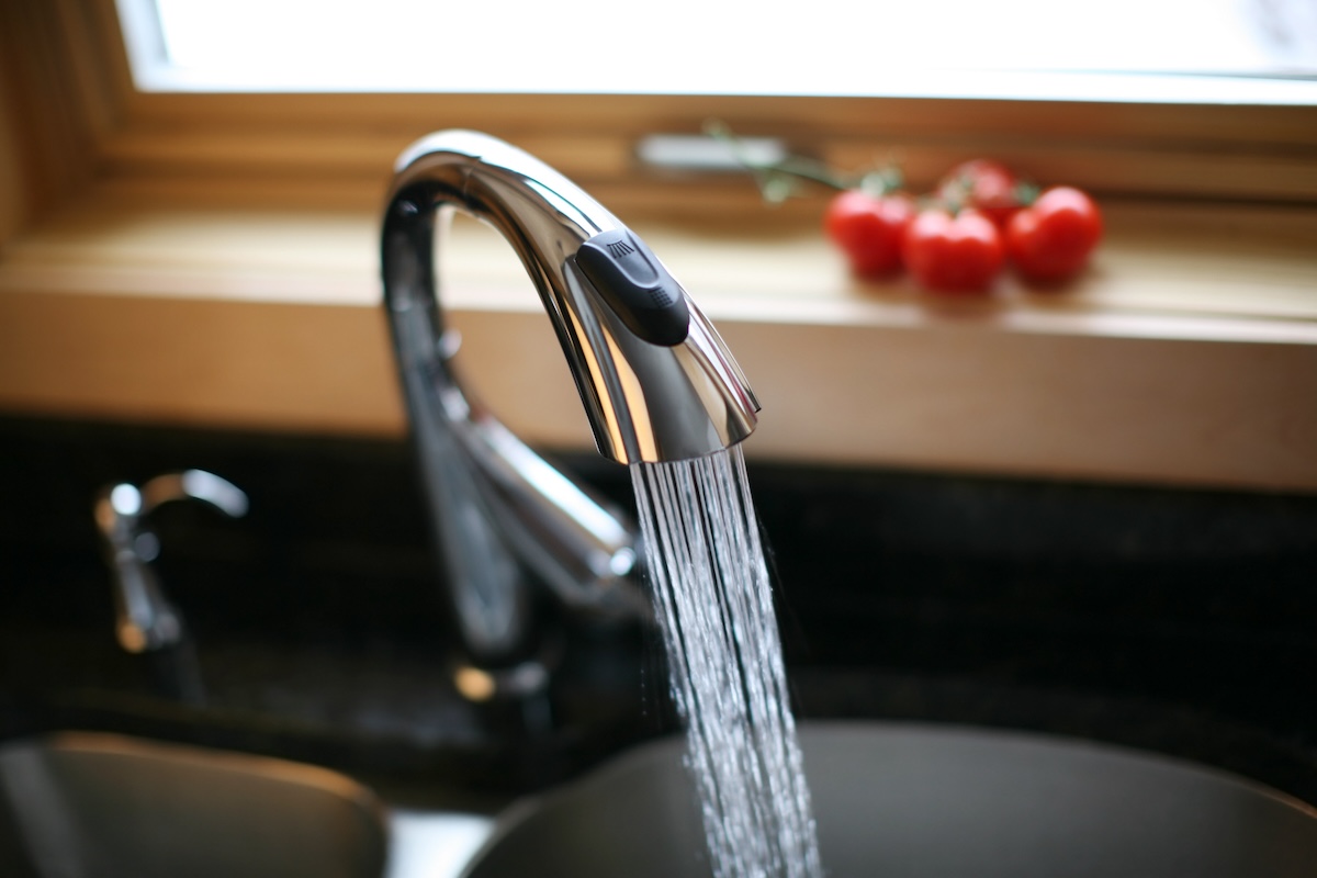 A low-flow kitchen faucet turned on.