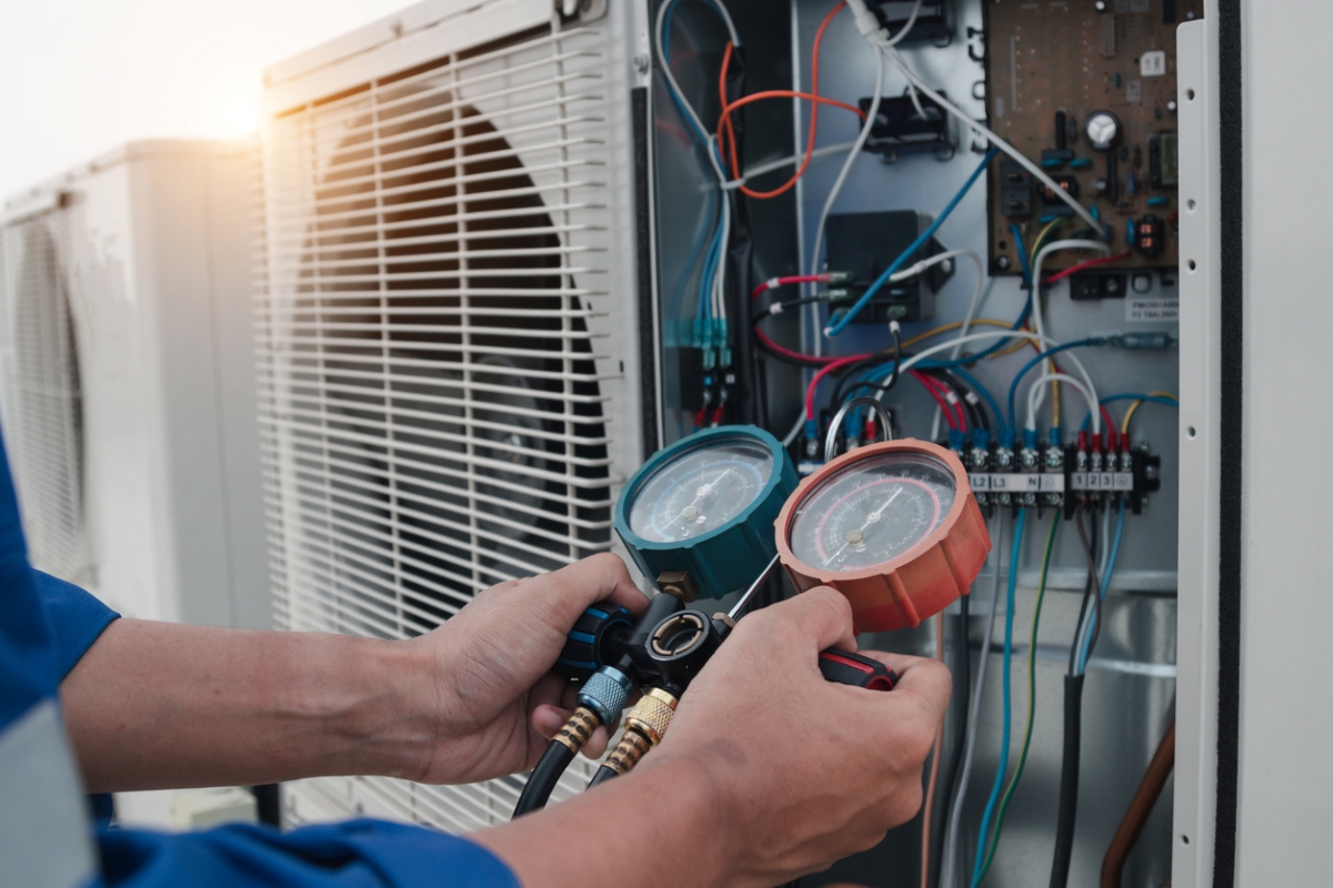 A technician is measuring air conditioner unit.