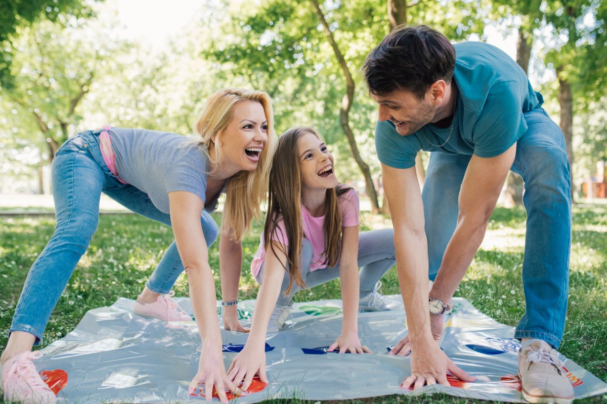 Family playing Twister outdoors.