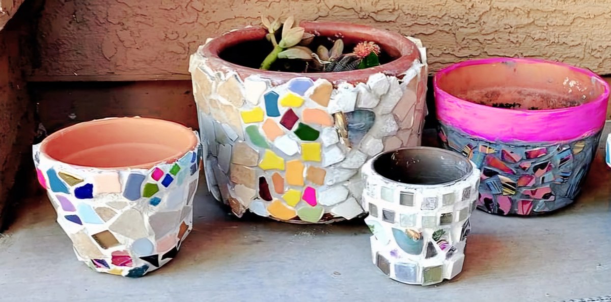 Planters made of broken tile mosaics sit in a row.
