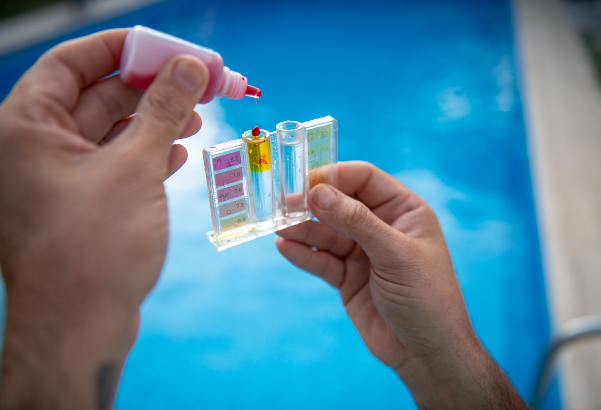 Using pool testing kit to test pH of swimming pool water.