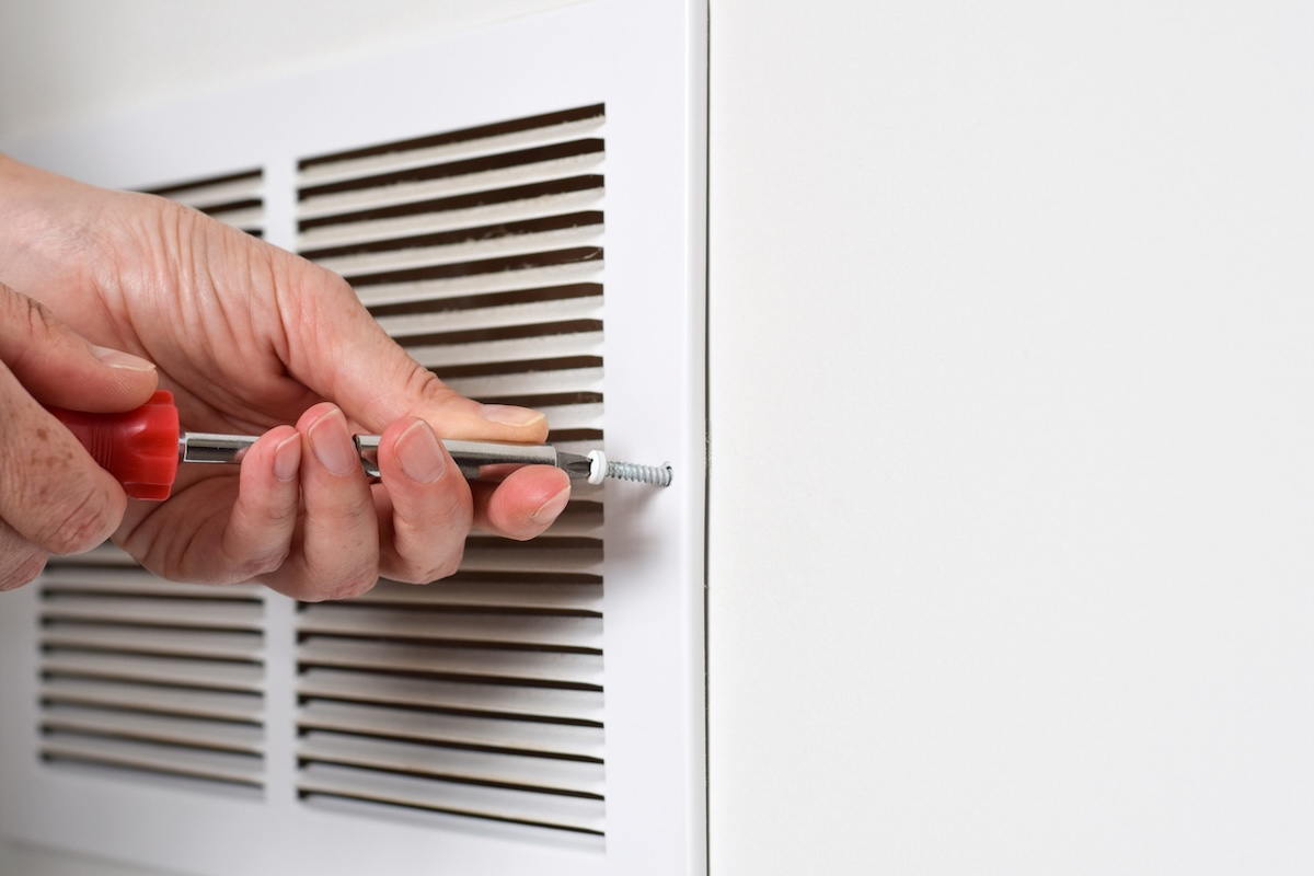 Using a red screwdriver to open interior air vent.