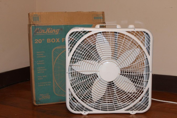 White Air King Commercial-Grade Box Fan on wood floor in front of box