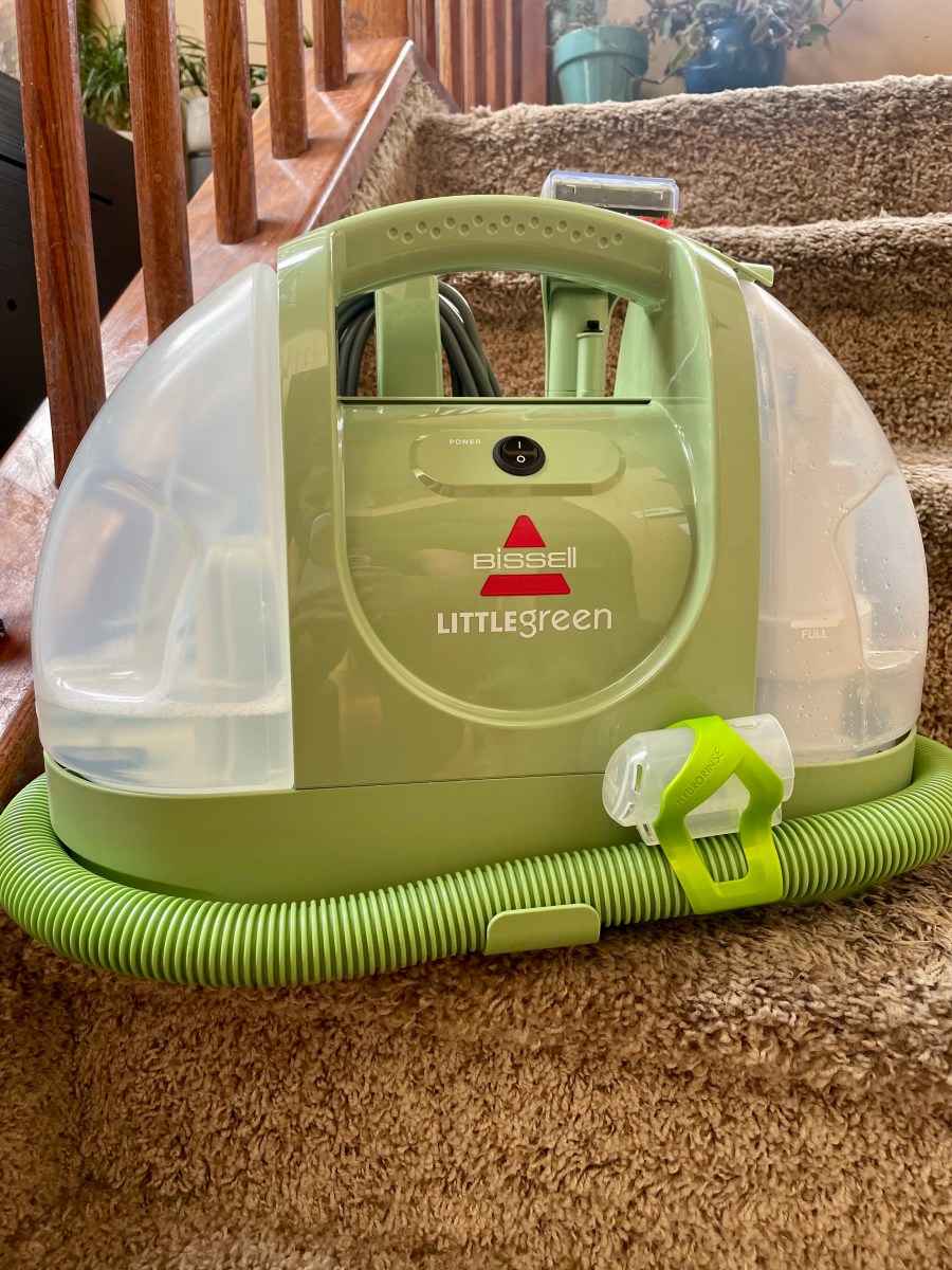 The Bissell Little Green carpet cleaner on a set of carpeted stairs during testing.